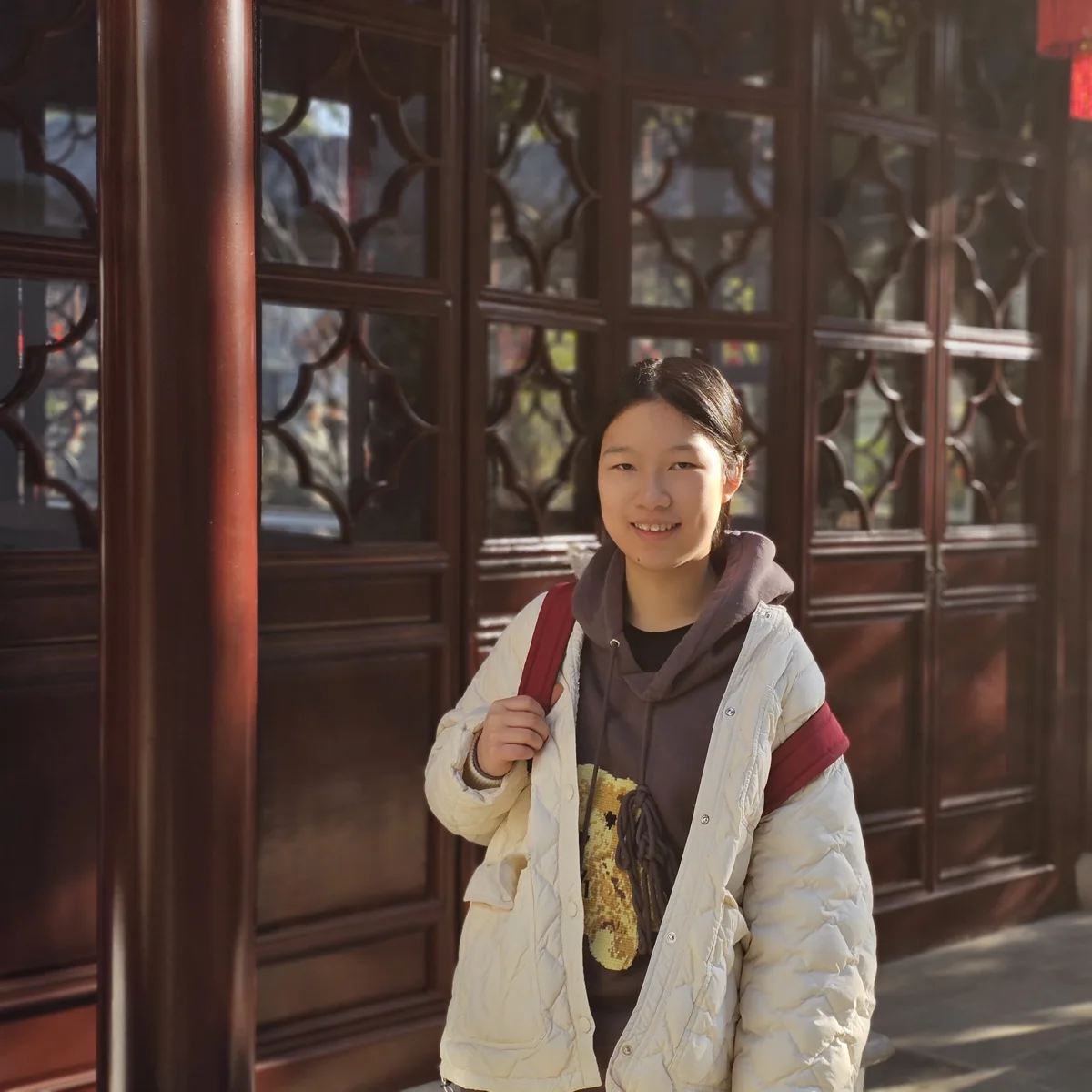 Snow smiling in front of carved wooden doors